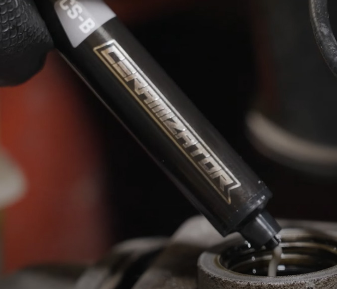 Ceramizator applicator being emptied into an engine oil filler neck